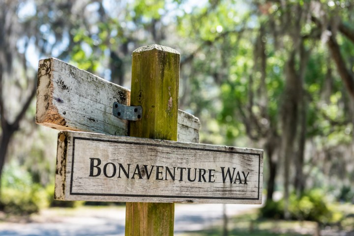 a sign on a wooden bench in a park